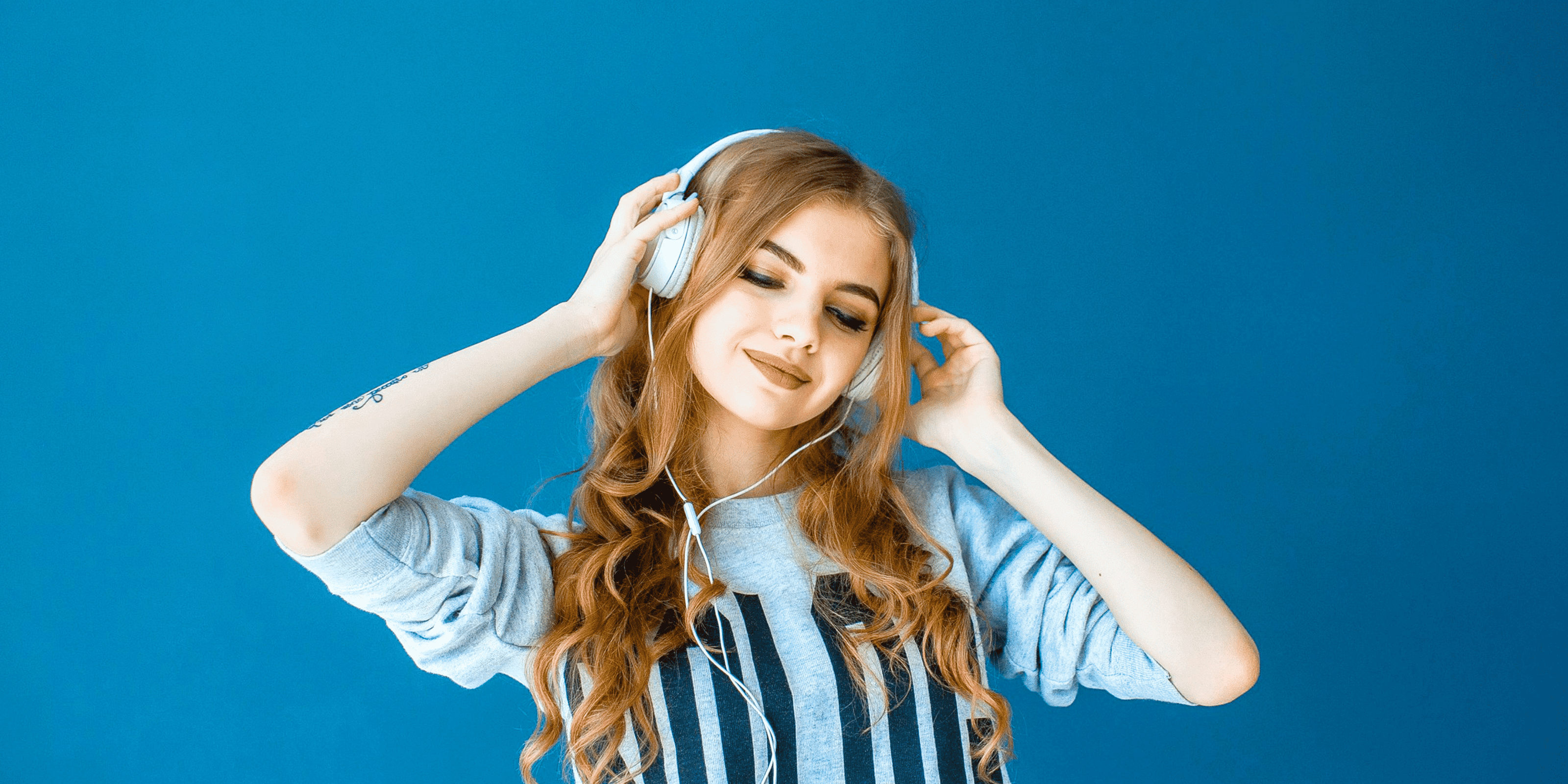 Mujer usando audífonos mientras sonrie