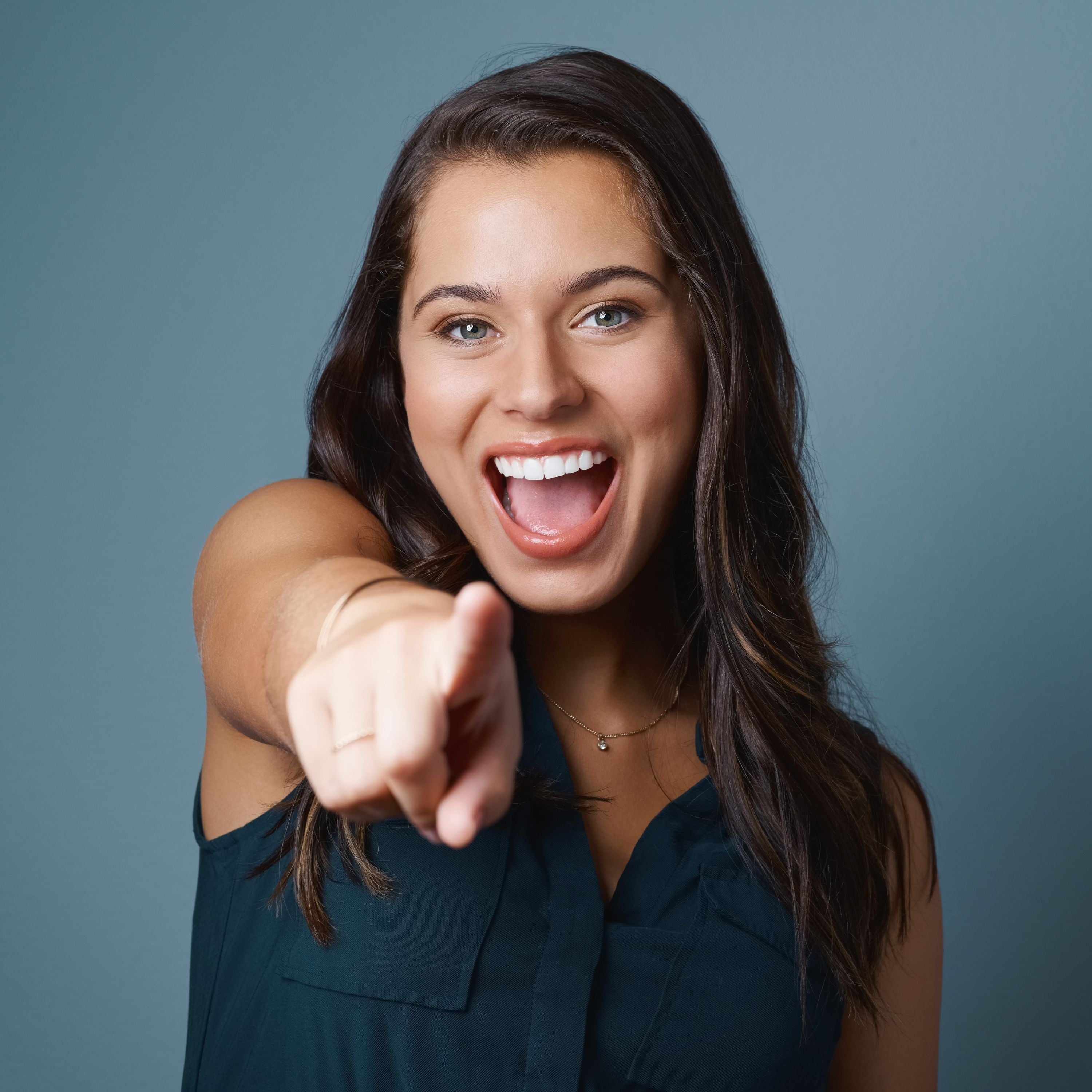 MUJER-SONRIENDO-SEÑALANDO-A-MONITOR